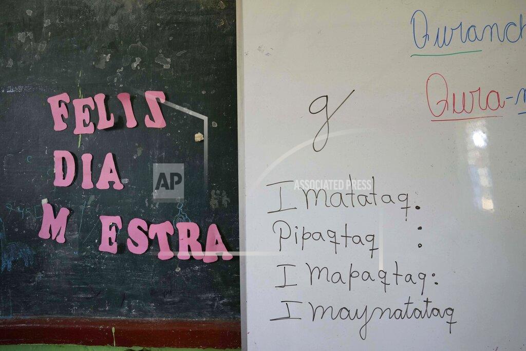 Martin Mejia The Spanish phrase "Happy Day Teacher," left, hangs next to a white board of words in the Indigenous Quechua language, during language class at a public primary school in Licapa, Peru, Wednesday, Sept. 1, 2021. More than 1.2 million children receive bilingual education in Spanish and Indigenous languages across Peru, a nation of about 32 million people. (AP Photo/Martin Mejia)