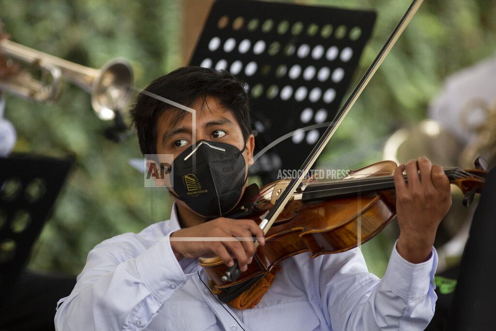 Moises Castillo A musician plays during a tribute by health workers at the San Juan de Dios hospital in memory of their colleagues who died from COVID-19, at the hospital in Guatemala City, Friday, Oct. 9, 2020. (AP Photo/Moises Castillo)