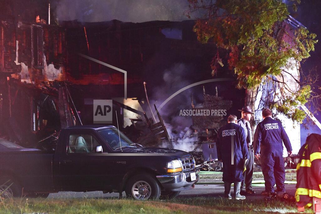 Jimmy May A Pennsylvania State trooper and members of the Luzerne County Coroner Office stand in front of an early morning fatal fire at 733 First Street in Nescopeck, Pa., Friday, Aug. 5, 2022. The fire was reported around 2:30 a.m. The cause of the fire remains under investigation. (Jimmy May/Bloomsburg Press Enterprise via AP)