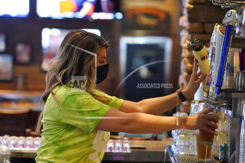 Darron Cummings Jillian Smith pours a beer for a customer at Kilroy's Bar & Grill, Sunday, March 14, 2021, in Indianapolis. The NCAA Tournament and bars were made for each other, with fans of powerhouse teams like Gonzaga and longshots like Colgate pouring in to cheer their teams. Until last year, that is, when COVID-19 blew up everybody’s brackets. This year, the tournament’s back, and bars and restaurants, some shuttered for months, are open for March Madness, though things may look a little different.(AP Photo/Darron Cummings)