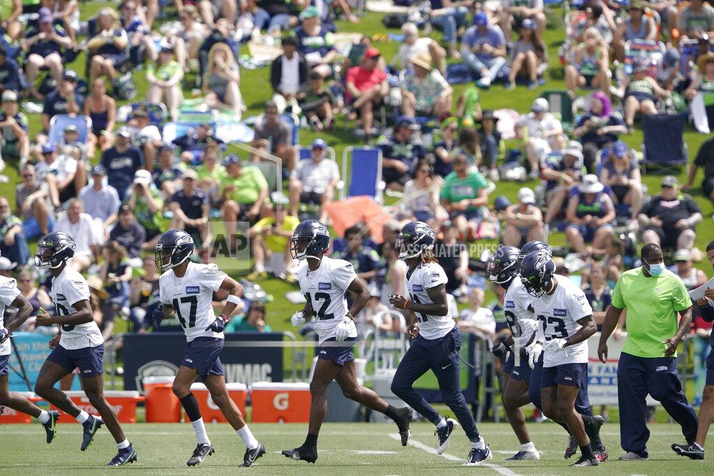 Ted S. Warren FILE - Seattle Seahawks defensive players run on the field as fans watch NFL football practice in Renton, Wash., in this Wednesday, July 28, 2021, file photo. It's not exactly everyone into the pool, or gathering around the bonfire. The NFL's “Back Together Saturday” at training camps is all about football. Well, also about having fans return to watch, with all 32 teams conducting open practices on Saturday, July 31, as part of a unified effort by the league. (AP Photo/Ted S. Warren, File)