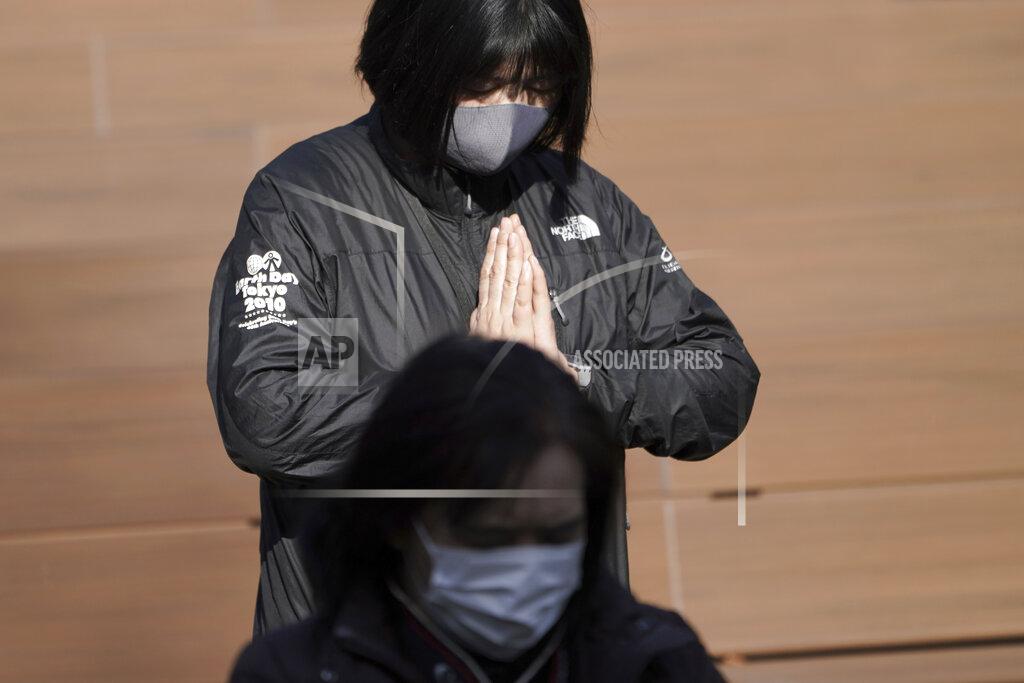 Eugene Hoshiko A staff member mourns for the victims of the 2011 earthquake and tsunami during an online special memorial event at Hibiya Park in Tokyo Thursday, March 11, 2021. Japan on Thursday marked the 10th anniversary of the massive earthquake, tsunami and nuclear disaster that struck Japan's northeastern coast. (AP Photo/Eugene Hoshiko)