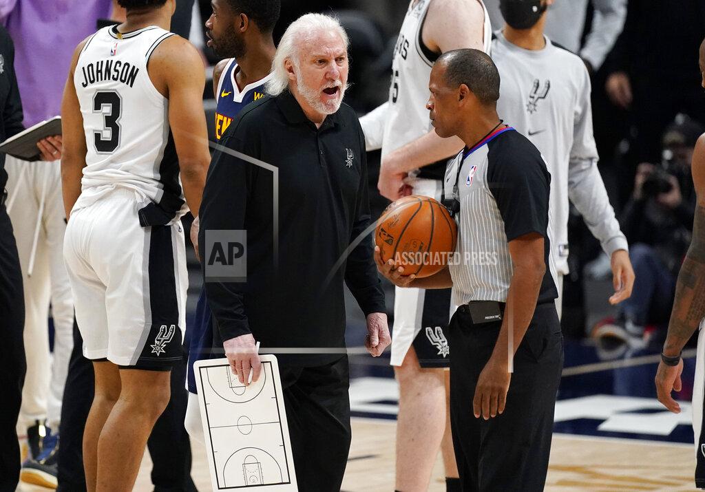 David Zalubowski San Antonio Spurs head coach Gregg Popovich, front left, argues with referee Eric Lewis after the Spurs missed a shot to tie the contest late in the second half of an NBA basketball game against the Denver Nuggets, Friday, April 9, 2021, in Denver. (AP Photo/David Zalubowski)