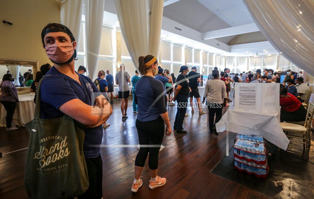 Ron Harris Voters wait in line to cast their ballots in the state's primary election at a polling place, Tuesday, June 9, 2020, in Atlanta, Ga. Some voting machines went dark and voters were left standing in long lines in humid weather as the waiting game played out. (AP Photo/Ron Harris)