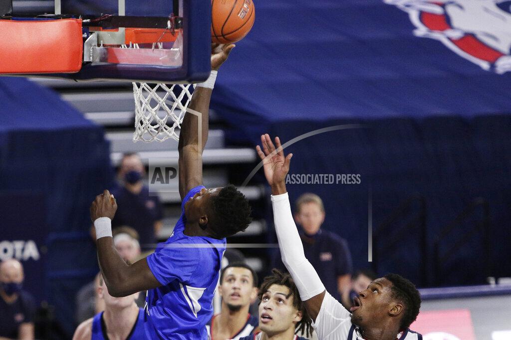 Young Kwak BYU forward Gideon George, left, shoots in front of Gonzaga guard Joel Ayayi, right, during the first half of an NCAA college basketball game in Spokane, Wash., Thursday, Jan. 7, 2021. (AP Photo/Young Kwak)