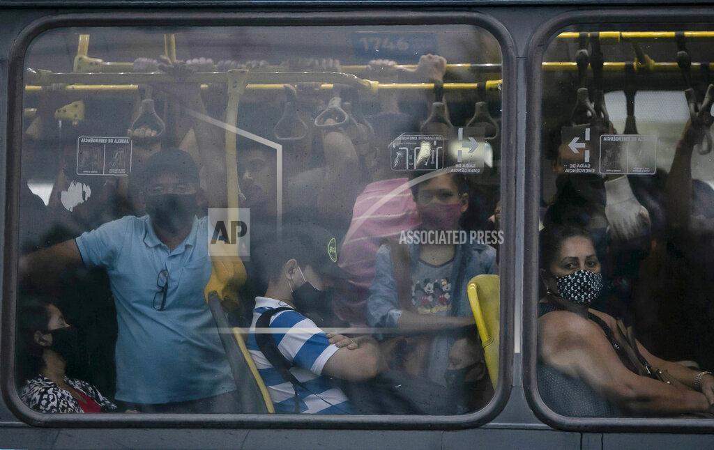 Bruna Prado FILE - In this March 30, 2021 file photo, commuters wearing protective face masks ride in a crowded public bus during the COVID-19 pandemic in Rio de Janeiro, Brazil. The region's well-heeled are flying to the U.S. to get vaccines, leaving the poor at the mercy of local vaccination schedules. (AP Photo/Bruna Prado, File)