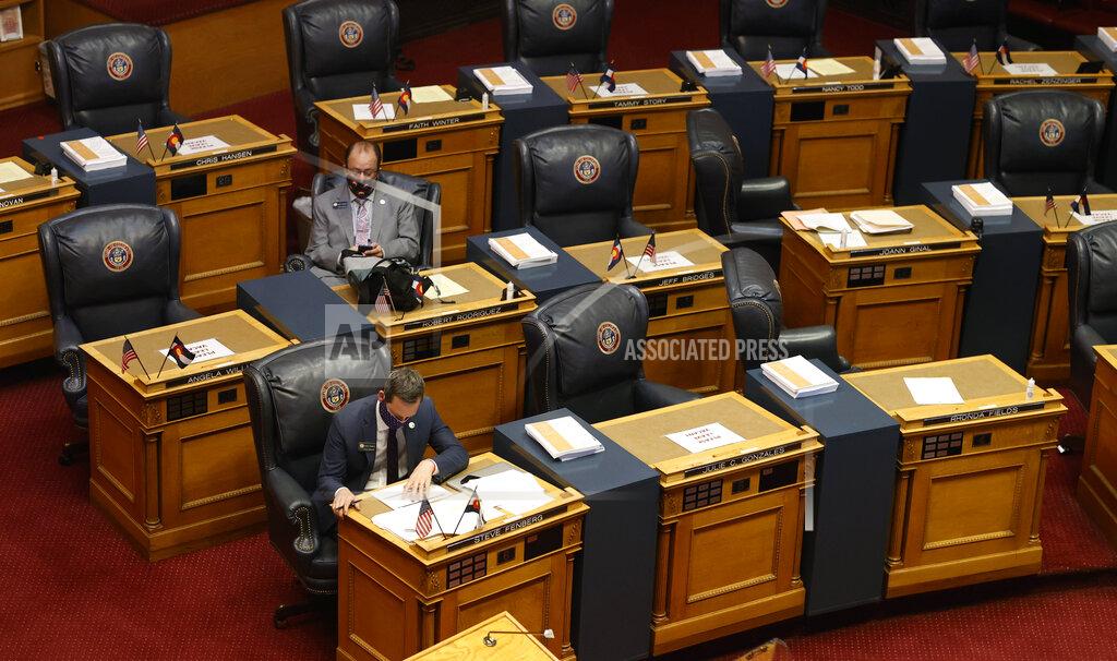 David Zalubowski FILE - In this May 26, 2020, file photo, state Sen. Steve Fenberg, D-Boulder, front, and Sen. Robert Rodriguez, D-Denver, sit amid the empty desks before the chamber reopens in downtown Denver. Citing Congress' failure to pass a new economic relief package, Colorado's Democrat-led Legislature convened Monday, Nov. 30, 2020, in a special session called by Gov. Jared Polis to pass bills offering sales tax relief and state grants to small businesses, tenants and public school districts affected by the pandemic. (AP Photo/David Zalubowski, File)