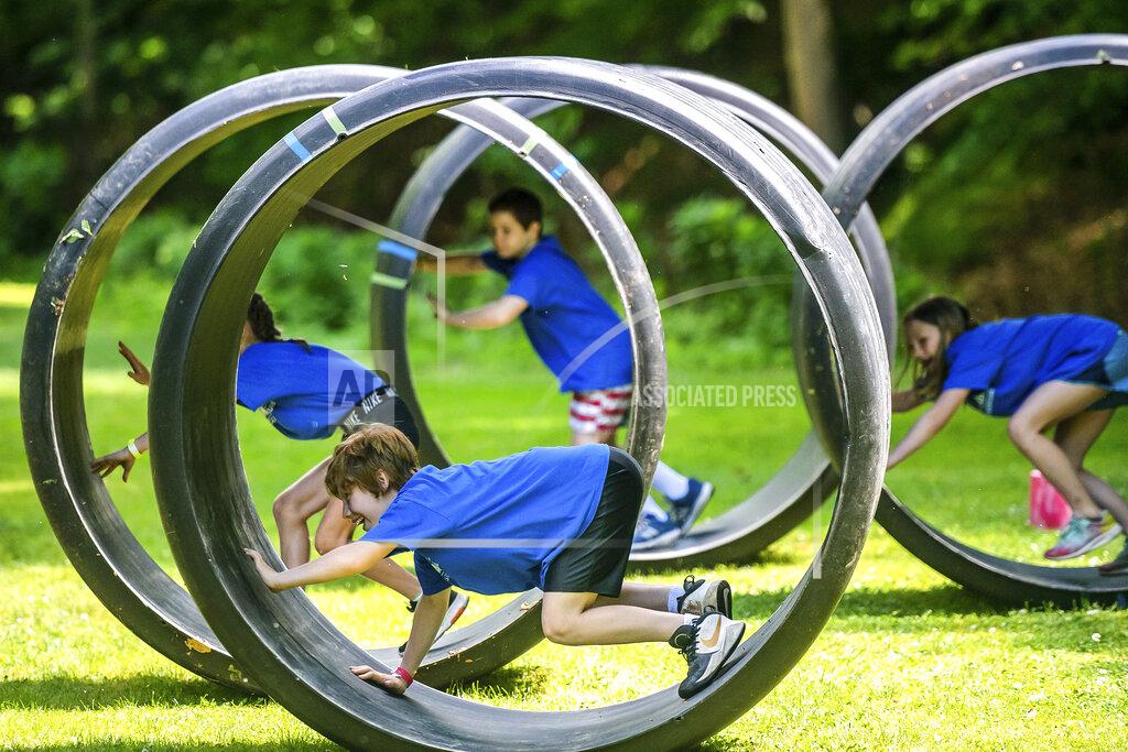 Fen Bohen, 9, of Gibsonia, participates in an obstacle course with fellow campers Thursday, June 11, 2020, at Camp Guyasuta in Sharpsburg, Pa. Camp Guyasuta's STEM Adventure Day Camp started for the summer on Monday, one of a handful of camps to open with adjusted protocols due to the COVID-19 pandemic. (Michael M. Santiago/Pittsburgh Post-Gazette via AP)