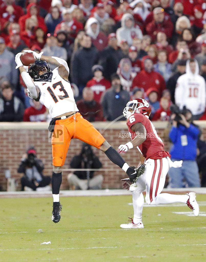 Alonzo Adams Oklahoma State wide receiver Tyron Johnson (13) makes a catch over Oklahoma cornerback Tre Brown (6) in the second half of an NCAA college football game in Norman, Okla., Saturday, Nov. 10, 2018. Oklahoma won 48-47. (AP Photo/Alonzo Adams)