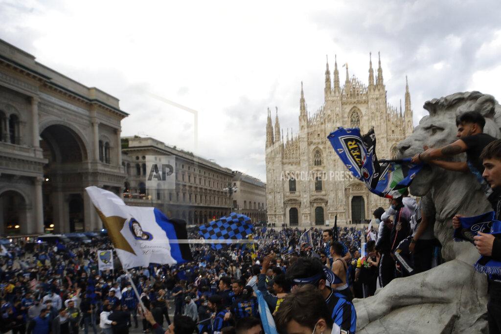 Luca Bruno Inter Milan fans celebrate and shout slogans in Piazza Duomo square in front of the gothic cathedral after Inter Milan won its first Serie A title in more than a decade after second-placed Atalanta drew 1-1 at Sassuolo, in Milan, Italy, Sunday, May 2, 2021. Atalanta needed to win to avoid Inter mathematically clinching the title with four matches remaining. It was Inter's first trophy since 2011 and the first Serie A title since 2010. (AP Photo/Luca Bruno)