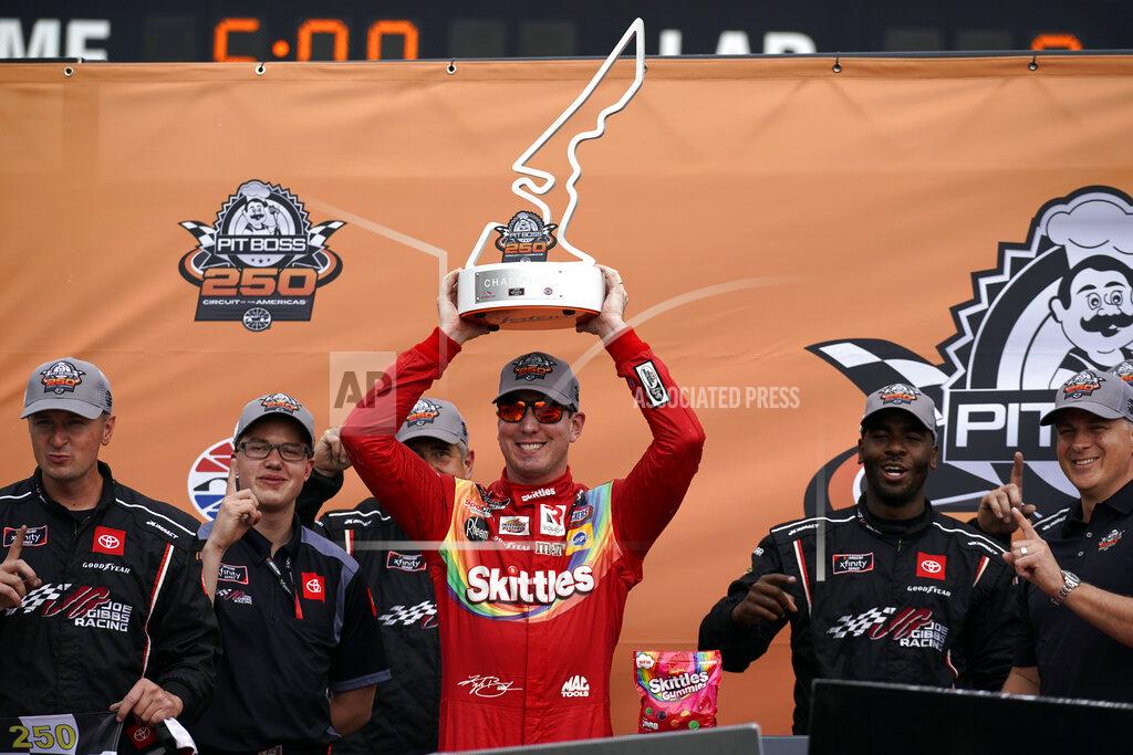 Chuck Burton Kyle Busch raises the trophy in Victory Lane after winning the NASCAR Xfinity Series auto race at the Circuit of the Americas in Austin, Texas, Saturday, May 22, 2021. (AP Photo/Chuck Burton)