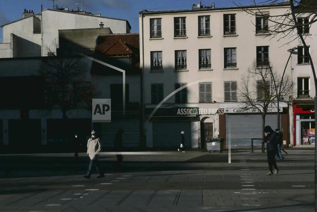 Christophe Ena People walk in a street of Saint-Denis, north Paris, Monday, Jan. 25, 2021. Many people lining up for vaccines in the Paris suburb are particularly grateful for the injections. The surrounding region is the poorest in mainland France, with 130 languages spoken and the country's highest rise in mortality last spring. (AP Photo/Christophe Ena)