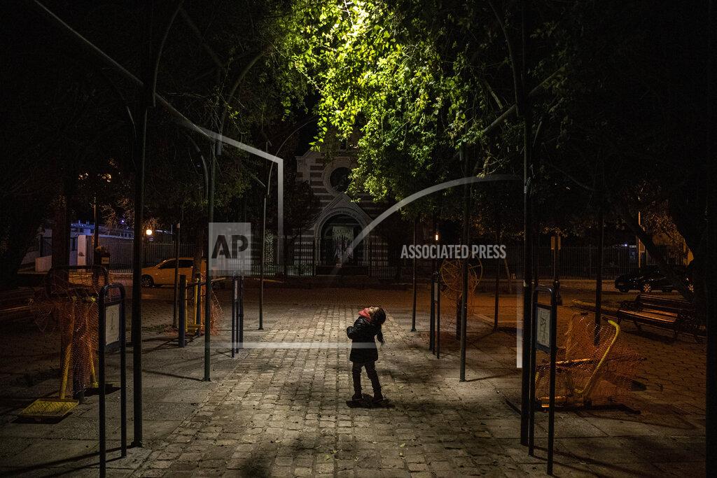 Esteban Felix Kehity Collantes, 5, looks up at the light in a park where she came with her father to speak with a family friend in Santiago, Chile, Sunday, Aug. 30, 2020, two months after her mother died of COVID-19. For many pandemic survivors and those who lost loved ones, like the five-year-old Collantes, the tragedy lingers and their lives are never the same. (AP Photo/Esteban Felix)