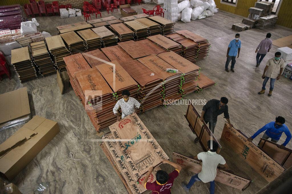 R S Iyer Civil defense volunteers stack beds and cots donated by the public for the treatment of COVID-19 positive people at a collection center in Kochi, Kerala state, India, Tuesday, July 28, 2020. India is the third hardest-hit country by the pandemic in the world after the United States and Brazil. (AP Photo/R S Iyer)