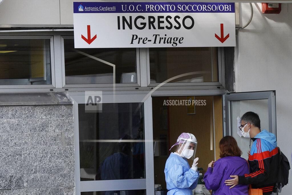 Gregorio Borgia A paramedic talks with relatives of a patient outside the first aid department of the Cardarelli hospital in Naples, Italy, Friday, Nov. 13, 2020. Outside the ER entrance of Cardarelli, the main health care facility for densely populated Naples, those desperate for oxygen for loved ones lined up in their cars, waiting for nurses to bring tanks of the life-saving element. (AP Photo/Gregorio Borgia)