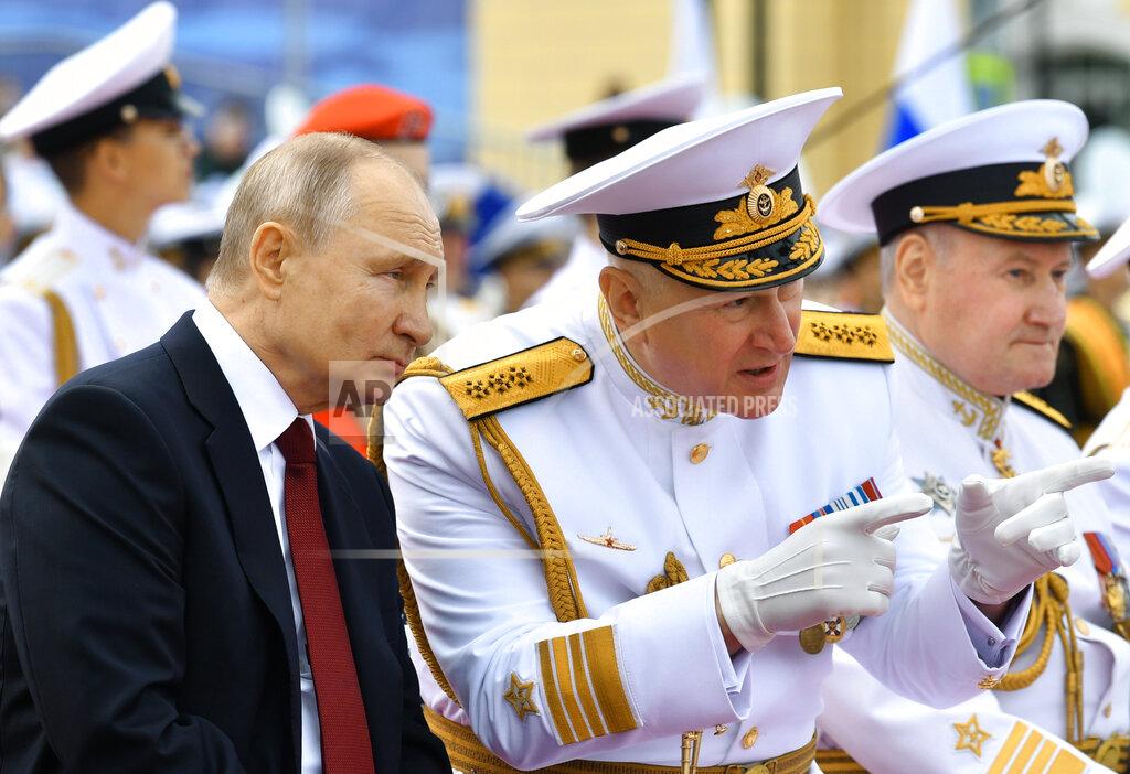 Alexei Nikolsky Russian President Vladimir Putin, left, listens to Admiral Nikolai Yevmenov, Commander-in-Chief of the Russian Navy, second right, while watching the Navy Day parade in St.Petersburg, Russia, Sunday, July 25, 2021. (Alexei Nikolsky, Sputnik, Kremlin Pool Photo via AP)