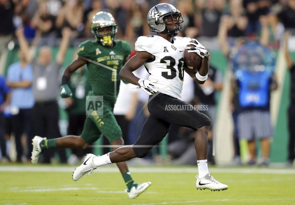 Mike Carlson Central Florida's Greg McCrae runs past South Florida's Mike Hampton to score a touchdown during the first half of an NCAA college football game Friday, Nov. 23, 2018, in Tampa, Fla. (AP Photo/Mike Carlson)