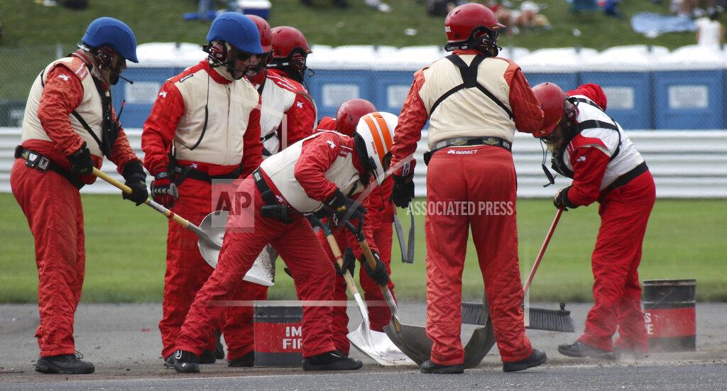 Bob Ruddick Crews clean up the track after a massive crash caused by a piece of curbing during a NASCAR Series auto race at Indianapolis Motor Speedway, Sunday, Aug. 15, 2021, in Indianapolis. (Bob Ruddick/The Indianapolis Star via AP)