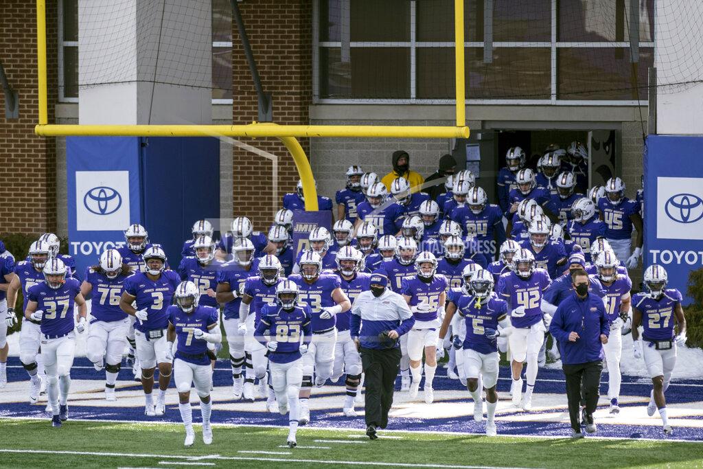 FILE - The James Madison team runs out onto the field before an NCAA college football game against Morehead State in Harrisonburg, Va., in this Saturday, Feb. 20, 2021, file photo. James Madison remains solidly atop the STATS Perform FCS Top 25, but the Dukes could go into the playoffs on April 24 having played once in six weeks. (Daniel Lin/Daily News-Record via AP, File)