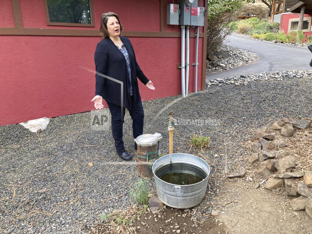 Andrew Selsky In this Tuesday, Oct. 5, 2021, photo, Dawn Rasmussen stands at her well at her property on the outskirts of The Dalles, Oregon. She says the water table that her well draws from has dropped 15 feet in the last 15 years. She has deep concerns about Google's proposal to build more data centers, which use vast amounts of water, in the town. The city council is expected to vote soon on Google's proposal. As demand for cloud computing grows, the world's biggest tech companies are building more data centers, including in arid regions even though they use vast amounts of water per day. (AP Photo/Andrew Selsky)