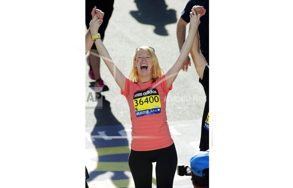 Charles Krupa FILE - In this April 21, 2014 file photo Adrianne Haslet-Davis raises her arms at the finish line of the 118th Boston Marathon, after she completed a short distance of the course in Boston. The Boston Marathon bombing survivor, who had planned on running this year's race, says she can't physically do it after getting struck by a car last month. (AP Photo/Charles Krupa, File)