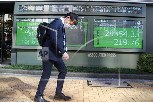A man walks by an electronic stock board of a securities firm in Tokyo, Wednesday, Nov. 24, 2021. Asian shares fell Wednesday, as worries about inflation set off expectations the U.S. Federal Reserve might raise interest rates.(AP Photo/Koji Sasahara)