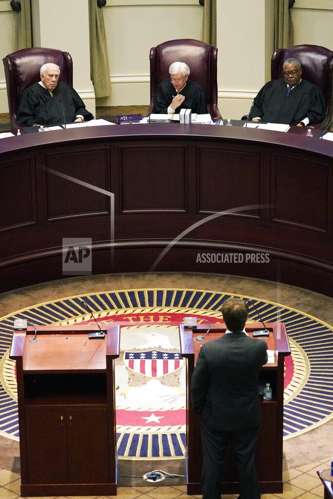 Rogelio V. Solis Mississippi Supreme Court Chief Justice Michael Randolph, center, flanked on by Presiding Justices James Kitchens, left, and Leslie King, questions attorney Justin Matheny of the Mississippi attorney general's office, during arguments over a lawsuit that challenges the state's initiative process and seeks to overturn a medical marijuana initiative that voters approved in November, Wednesday, April 14, 2021, in Jackson, Miss. (AP Photo/Rogelio V. Solis)
