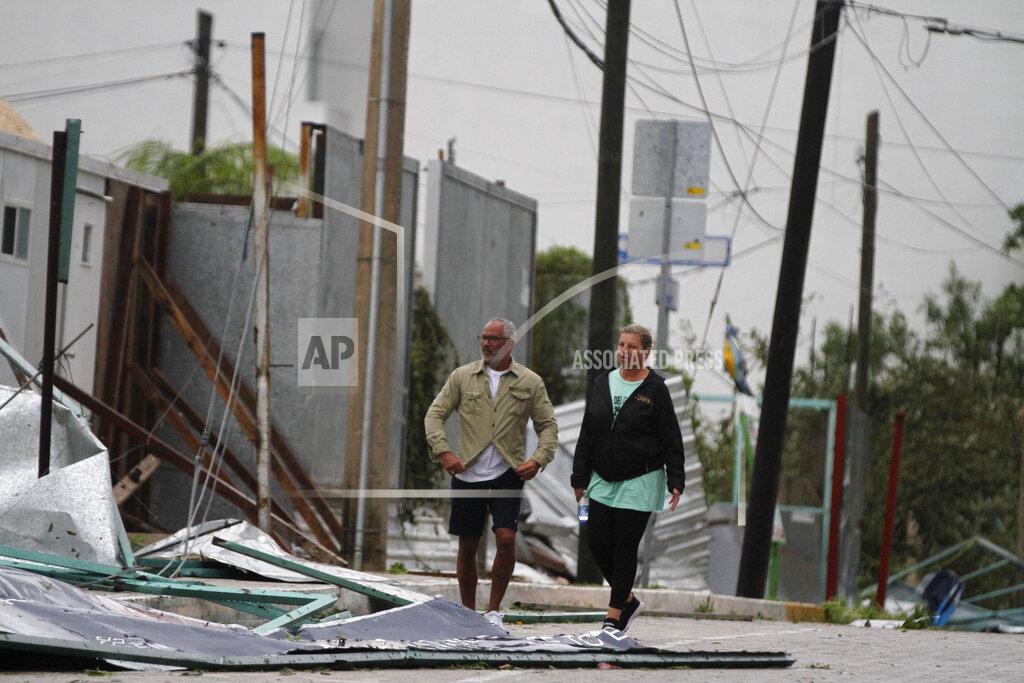 Tomas Stargardter Tourists walk past debris littering the street after Hurricane Zeta's landfall in Playa del Carmen, Mexico, early Tuesday, Oct. 27, 2020. Zeta is leaving Mexico’s Yucatan Peninsula on a path that could hit New Orleans Wednesday night. (AP Photo/Tomas Stargardter)