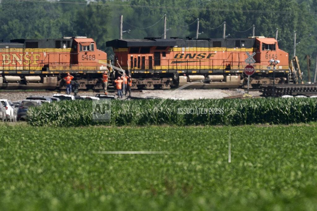 Charlie Riedel Workers watch Tuesday, June 28, 2022 as a freight train moves through the crossing where an Amtrak train derailed Monday near Mendon, Mo. The train derailed after hitting a dump truck Monday killing the truck driver and other people on the train and injuring several dozen other passengers on the Chicago-bound train. (AP Photo/Charlie Riedel)