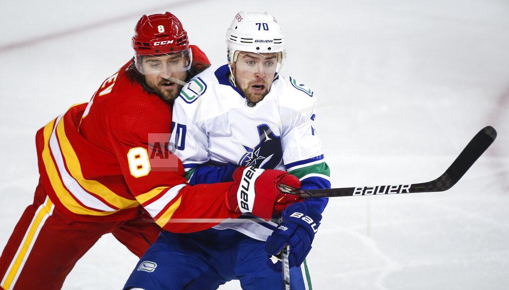 Jeff Mcintosh Vancouver Canucks' Tanner Pearson, right, is checked by Calgary Flames' Christopher Tanev during the second period of an NHL hockey game Thursday, May 13, 2021, in Calgary, Alberta. (Jeff McIntosh/The Canadian Press via AP)