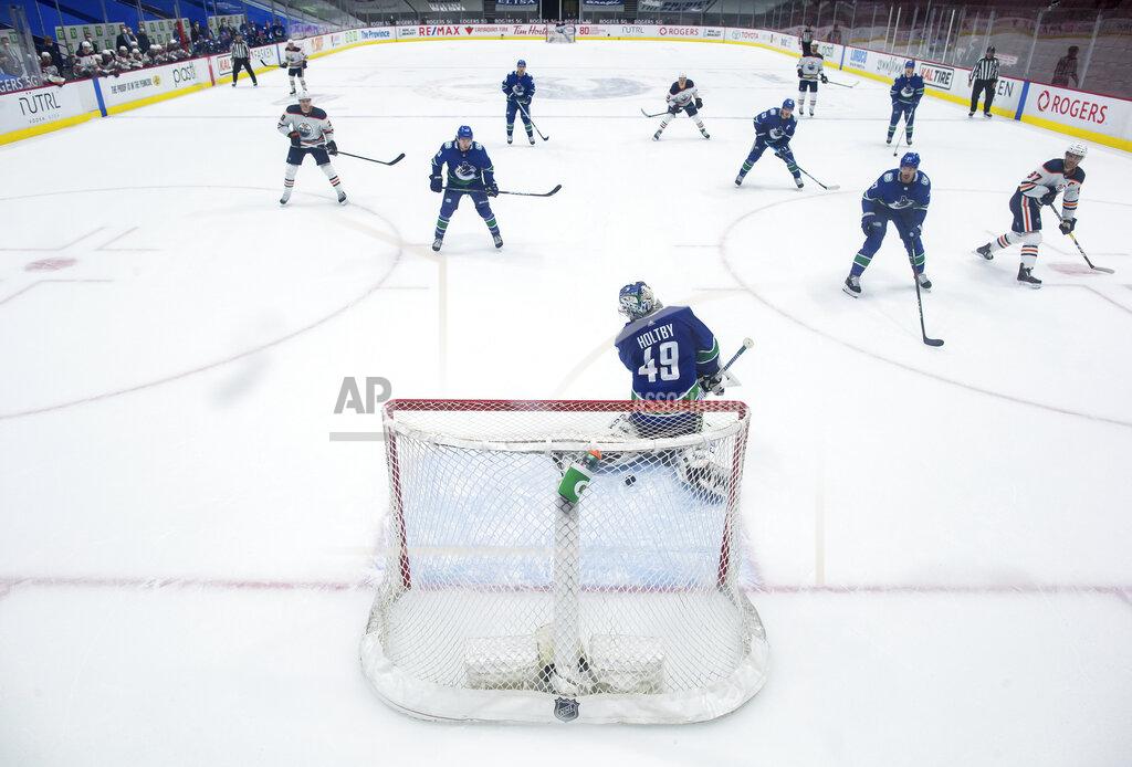 Darryl Dyck Edmonton Oilers' Connor McDavid, far right, scores against Vancouver Canucks goalie Braden Holtby (49) during the second period of an NHL hockey game, Monday, May 3, 2021, in Vancouver, British Columbia. (Darryl Dyck/The Canadian Press via AP)
