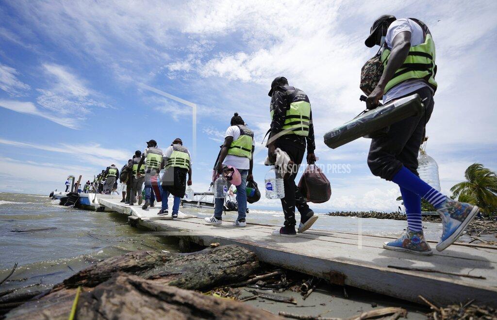 Fernando Vergara Haitian migrants board a boat that will take them to Acandi, near the border with Panama, as they depart Necocli, Colombia, Monday, Sept. 13, 2021. Migrants have been gathering in Necocli as they move north on their way to the U.S. border. (AP Photo/Fernando Vergara)