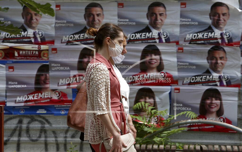 Boris Grdanoski Two women walk past campaign posters of the ruling SDSM party in Skopje, North Macedonia on Thursday, July 16, 2020, a day after the country's parliamentary elections. The pro-Western SDSM party in North Macedonia is poised to try to form a coalition government following a narrow election victory. (AP Photo/Boris Grdanoski)