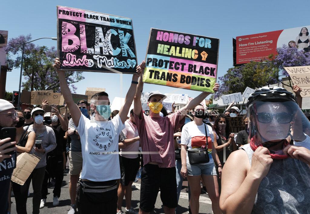 Richard Vogel LGBTQ community members raise signs and join in support of Black Lives Matter during a protest at an intersection in West Hollywood, Calif. on Wednesday, June 3, 2020, over the death of George Floyd. Floyd died after being restrained by Minneapolis police officers on Memorial Day. (AP Photo/Richard Vogel)
