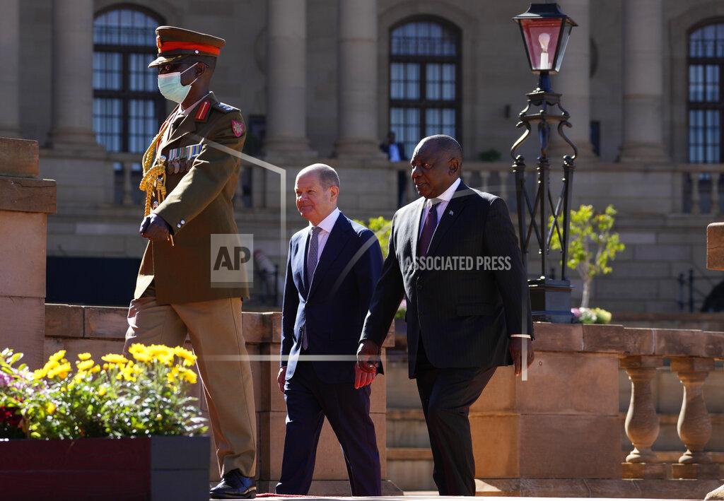 Themba Hadebe German Chancellor Olaf Scholz, center, walks with South Africa President Cyril Ramaphosa after the official welcoming ceremony at the Union Building in Pretoria, South Africa, Tuesday, May 24, 2022. (AP Photo/Themba Hadebe)