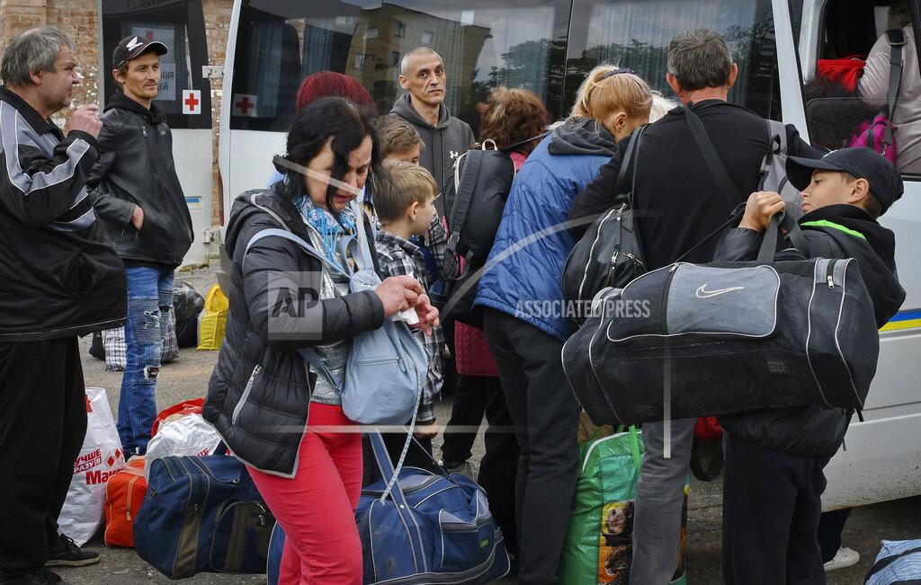 Andriy Andriyenko People board transport during an evacuation of civilians in Soledar, Donetsk region, Ukraine, Tuesday, May 24, 2022. (AP Photo/Andriy Andriyenko)
