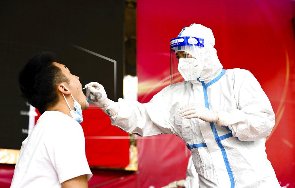 Wang Guansen FILE - In this July 5, 2021, file photo released by Xinhua News Agency, a medical worker collects a swab sample for nucleic acid test in Ruili City of southwest China's Yunnan Province. Everyone in a county in China's southwest near Myanmar will be tested for the coronavirus following a spike in infections, the government announced Saturday, July 24, 2021. (Wang Guansen/Xinhua via AP, File)
