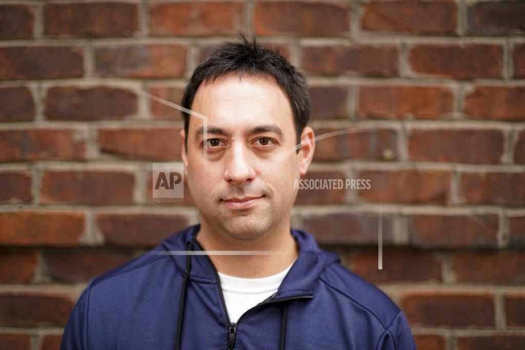 Chris Carlson Evan Metaxatos poses for a pictures on Monday, Nov. 30, 2020, in Charlotte, N.C. An analysis shows that few Americans are utilizing contact tracing technology launched in a host of U.S. states and territories. (AP Photo/Chris Carlson)