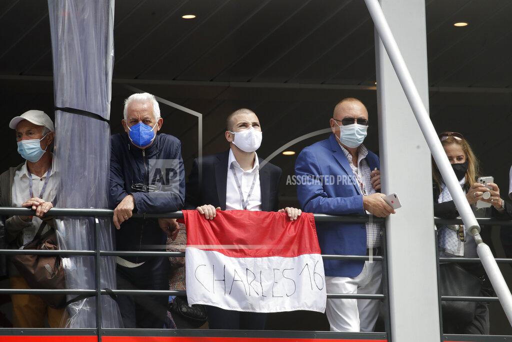 Luca Bruno Spectators stand on a balcony with a flag to cheer on Ferrari driver Charles Leclerc of Monaco prior to the Monaco Grand Prix at the Monaco racetrack, in Monaco, Sunday, May 23, 2021. (AP Photo/Luca Bruno)