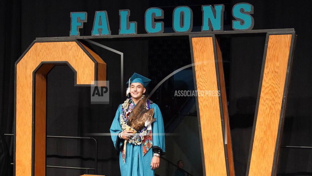 Rick Bowmer Dayne Hudson, member of the Paiute Indian Tribe of Utah, holds his eagle feather fan during the Canyon View High School graduation Wednesday, May 25, 2022, in Cedar City, Utah. Hudson said it was important to wear eagle feathers and a beaded cap to represent his family and honor those who were stopped from doing so under the old rule. (AP Photo/Rick Bowmer)