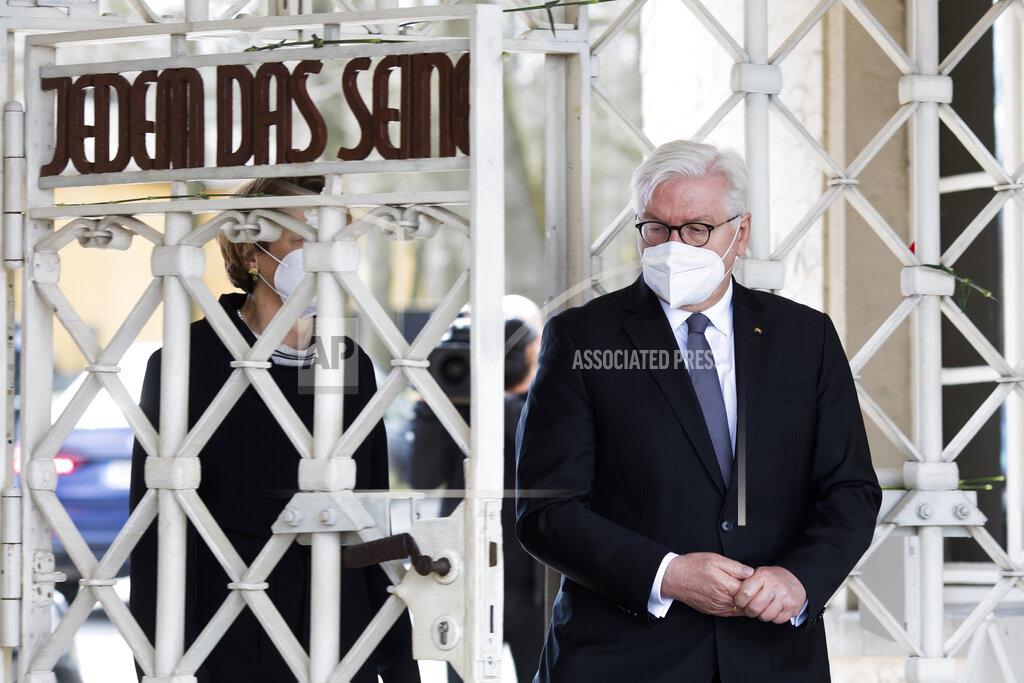 Markus Schreiber German President Frank-Walter Steinmeier, right, and his wife Elke Buendenbender, left, walk through the entrance gate of the Nazi concentration camp 'Buchenwald' with the inscription 'Jedem das Seine' (To Each His Own) as they arrive for commemorations marking the 76th anniversary of the liberation of the Nazi camp near Weimar, Germany, Sunday, April 11, 2021. On April 11, 1945 the US Army liberated the concentration camp Buchenwald. (AP Photo/Markus Schreiber)