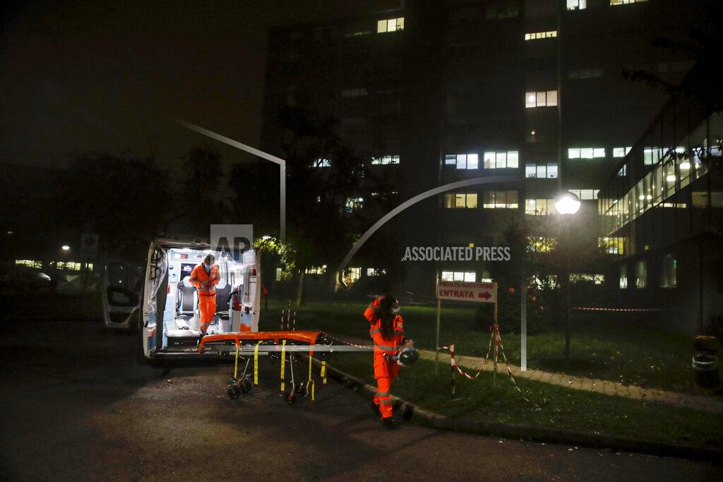 Luca Bruno Medical volunteer Beatrice Ammattatiello, right, and medical staffer Andrea Arosio take a moment of relax after carrying a suspected Covid patient to the Bassini hospital during their shift with the emergency White Cross ambulance, in Cinisello Balsamo, near Monza, Italy, Thursday, Nov. 19, 2020. The city of Monza north of Milan is best known for its Formula 1 racetrack. In 2020, it has been the ambulance service that has been doing most of the racing. Over three days that an Associated Press photographer traveled on night calls with an ambulance service, the Monza-Brianza province of some 875,000 bordering Milan added 2,500 new cases, part of Italy’s new epicenter in the Lombardy region. (AP Photo/Luca Bruno)