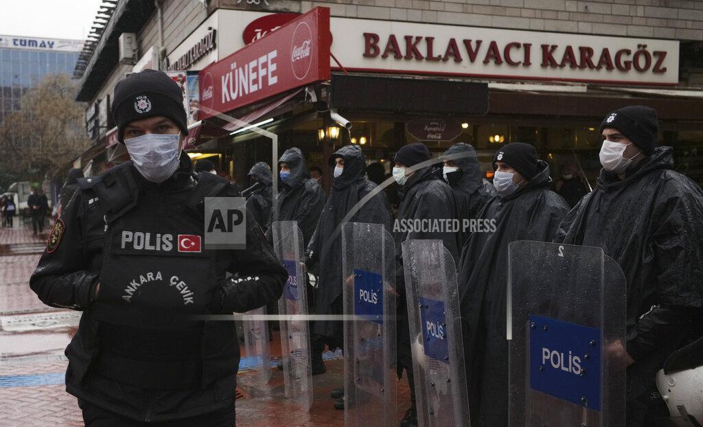 Burhan Ozbilici Riot police officers wearing masks to protect against the spread of coronavirus, stand in the rain during a women's right protest, in Ankara, Turkey, Saturday, March 20, 2021. Turkey's weekly geographic COVID-19 figures keep increasing according to Health ministry statistics released late Saturday as the country continues its "controlled normalization." (AP Photo/Burhan Ozbilici)