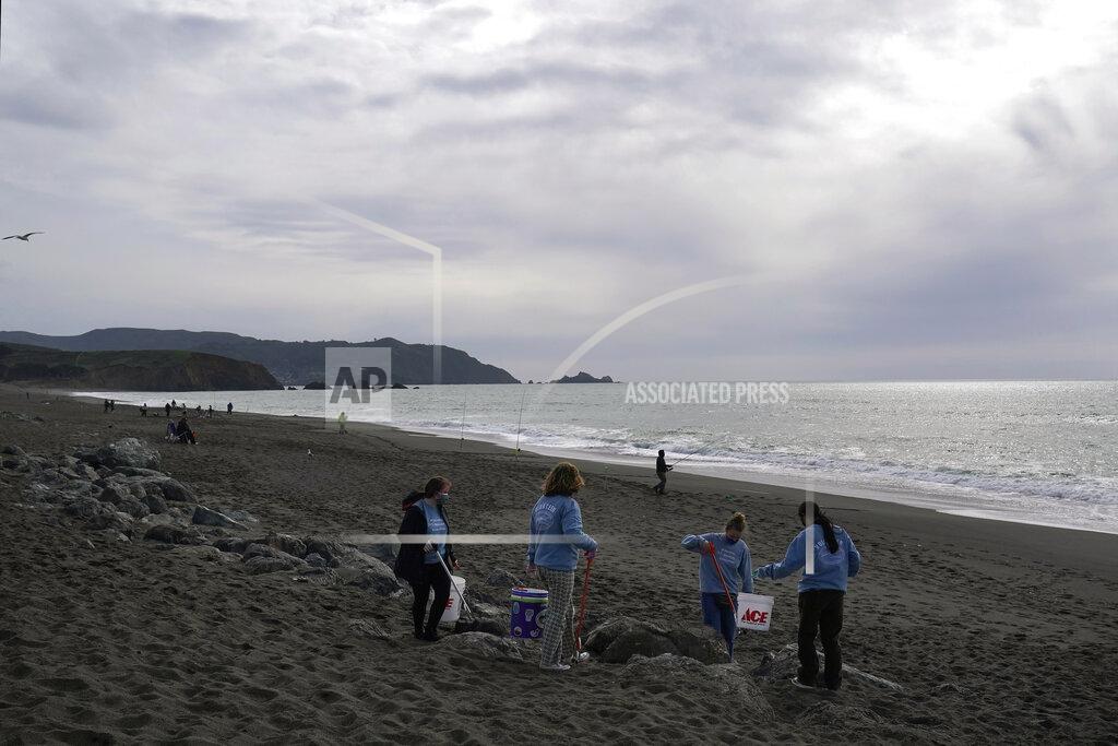 Jeff Chiu Pacifica Beach Coalition volunteers Iona Pratt-Bauman, from left, Anneliese Phillips, Sophia Woehl and Amaelia Bringas, all 16, pick up trash off Sharp Park Beach in Pacifica, Calif., Wednesday, March 17, 2021. Disposable masks, gloves and other personal protective equipment have safeguarded untold lives during the pandemic. They’re also creating a worldwide environmental problem, littering streets and sending an influx of harmful plastic into landfills and oceans. (AP Photo/Jeff Chiu)