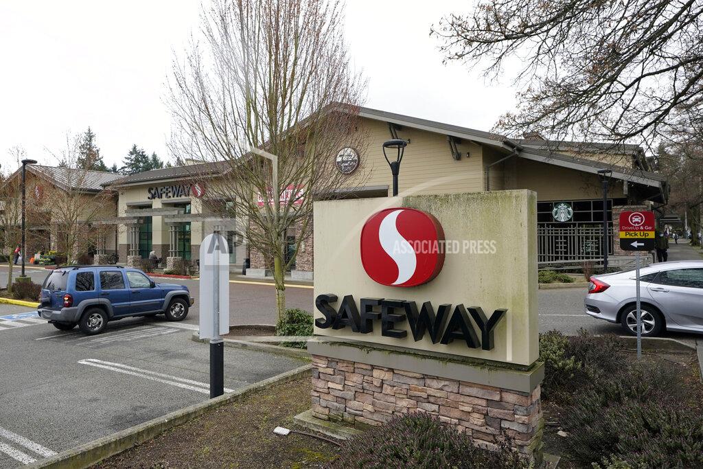 Cars come and go at a Safeway grocery store, Thursday, March 18, 2021, in Seattle. A federal judge on Thursday dismissed an industry lawsuit that sought to block a $4-an-hour pay increase for Seattle grocery workers amid the COVID-19 pandemic that was approved by the Seattle City Council in earlier in the year for workers at large grocery companies. (AP Photo/Ted S. Warren)
