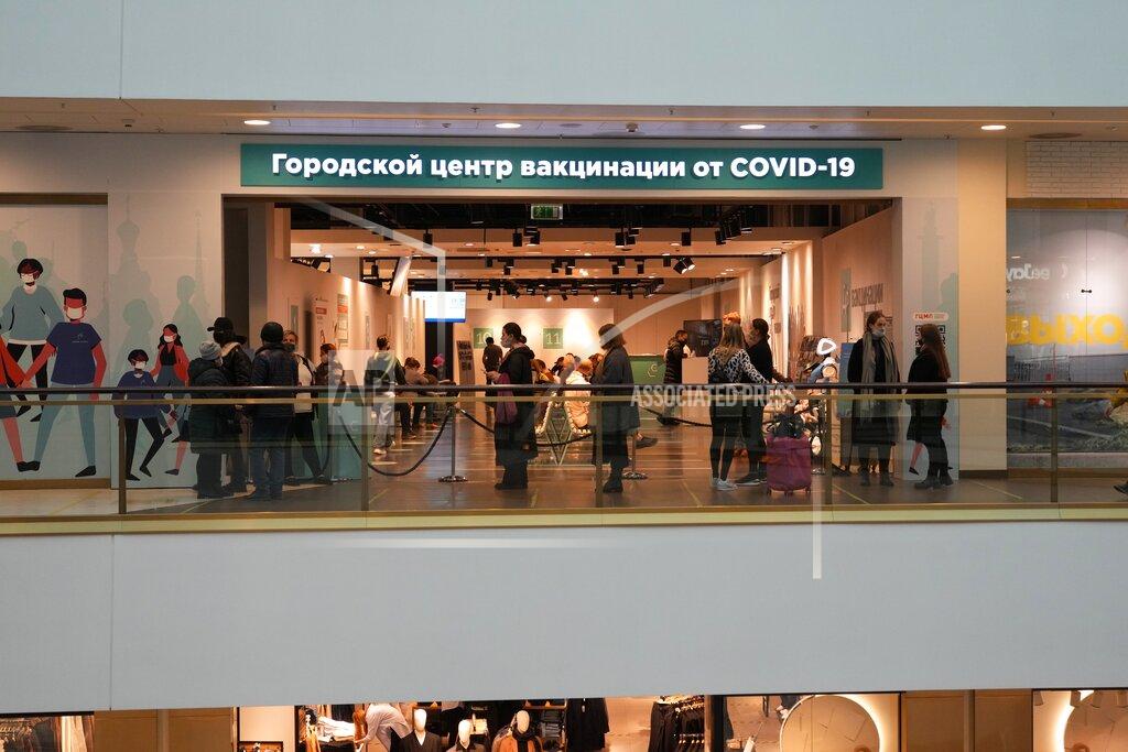 Dmitri Lovetsky People stand in line under a plaque reading "City center of vaccination against COVID-19" at a shopping mall in St. Petersburg, Russia, Monday, Oct. 25, 2021. Russia has reported another daily record of confirmed coronavirus cases as a surge in infections has prompted the Kremlin to tell most people to stay away from work starting later this week. Only about 45 million Russians — roughly a third of the country's nearly 146 million people — are fully vaccinated. (AP Photo/Dmitri Lovetsky)