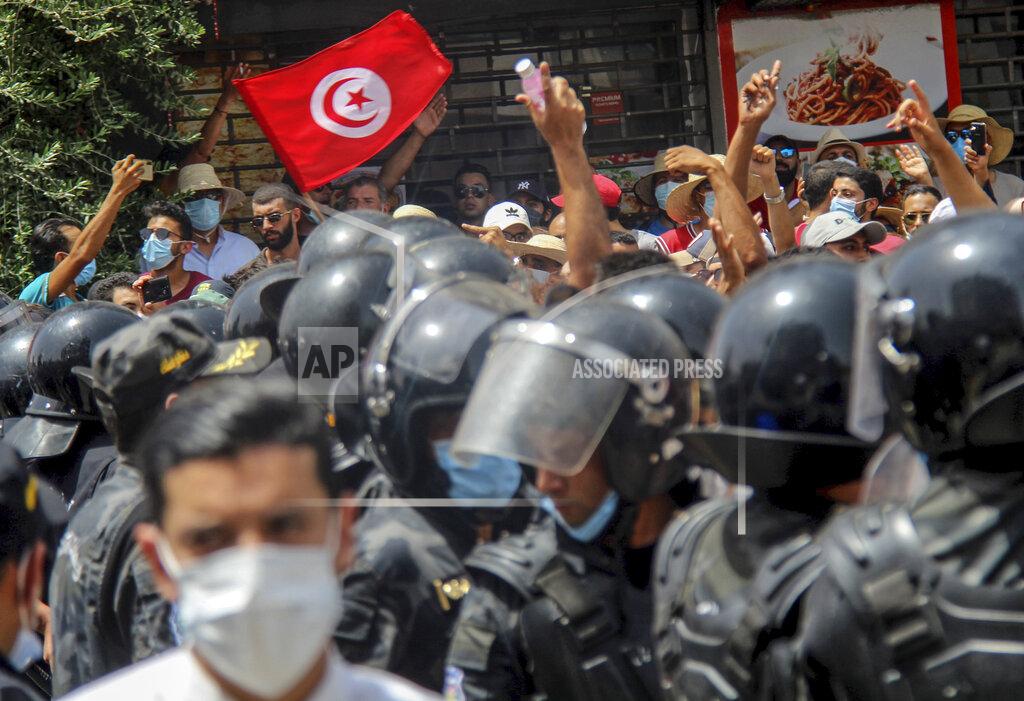 Hassene Dridi File - In this July 25, 2021 file photo, protesters face Tunisian police officers during a demonstration in Tunis, Tunisia. Days of political turmoil in Tunisia over the economy and the coronavirus have left its allies in the Middle East, Europe and the United States watching to see if the fragile democracy will survive. (AP Photo/Hassene Dridi, File)