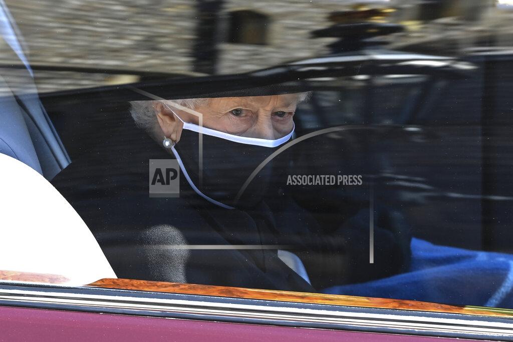 Leon Neal Britain's Queen Elizabeth II follows the coffin in a car as it makes it's way past the Round Tower during the funeral of Britain's Prince Philip inside Windsor Castle in Windsor, England Saturday April 17, 2021. (Leon Neal/Pool via AP)