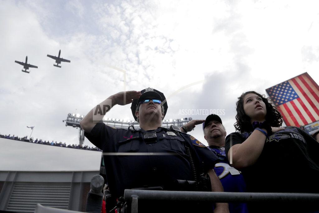 Julio Cortez A Baltimore Police officer salutes as two United States Air Force A-10 fighter jets conduct a flyover during the playing of the national anthem prior to an NFL football game between the Baltimore Ravens and the Cincinnati Bengals Sunday, Oct. 13, 2019, in Baltimore. (AP Photo/Julio Cortez)