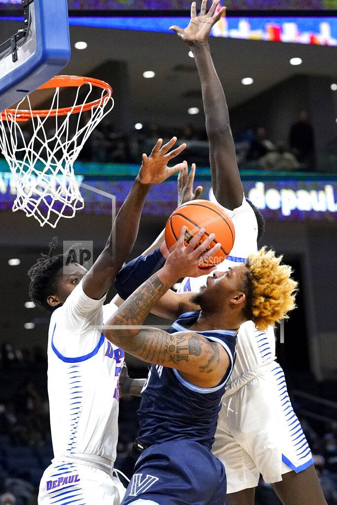 Nam Y. Huh Villanova guard Justin Moore, right, drives to the basket against DePaul forward David Jones, left, and forward Yor Anei during the first half of an NCAA college basketball game in Chicago, Saturday, Jan. 8, 2022. (AP Photo/Nam Y. Huh)